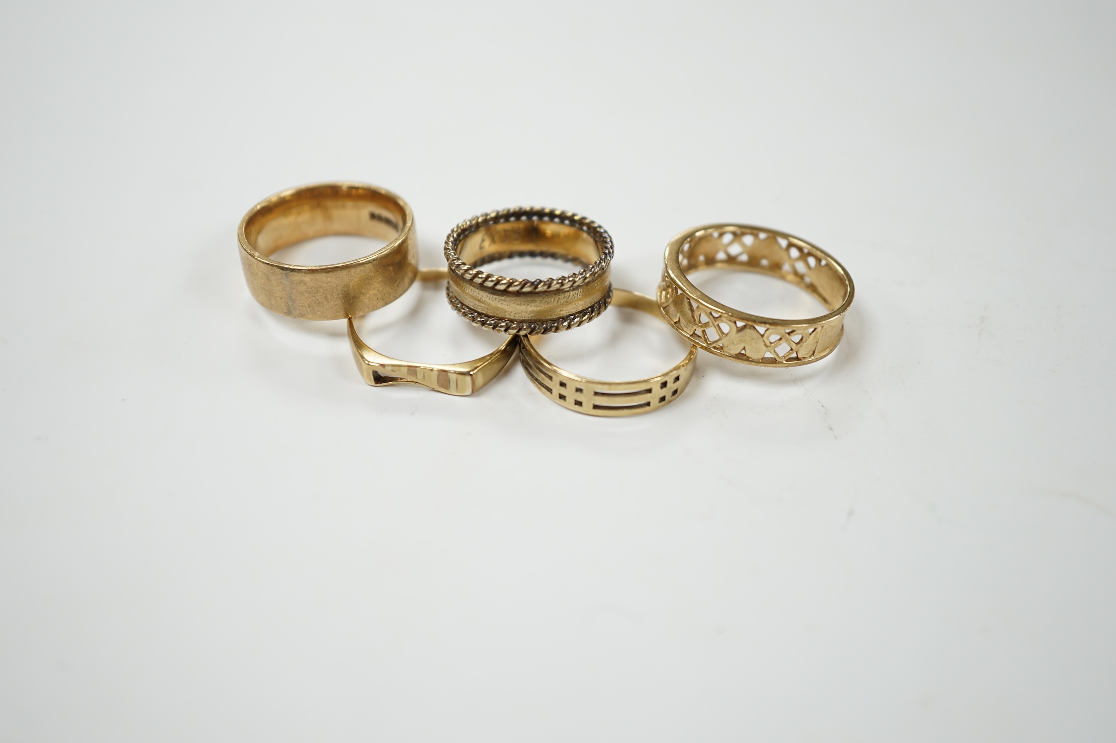 Five assorted 9ct gold bands, including two pierced, various sizes, 17.9 grams. Condition - poor to fair